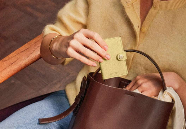 a woman putting her secrid wallet on her bag